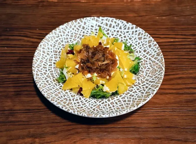 Ensalada Tukah con queso de cabra, cebolla caramelizada y naranja